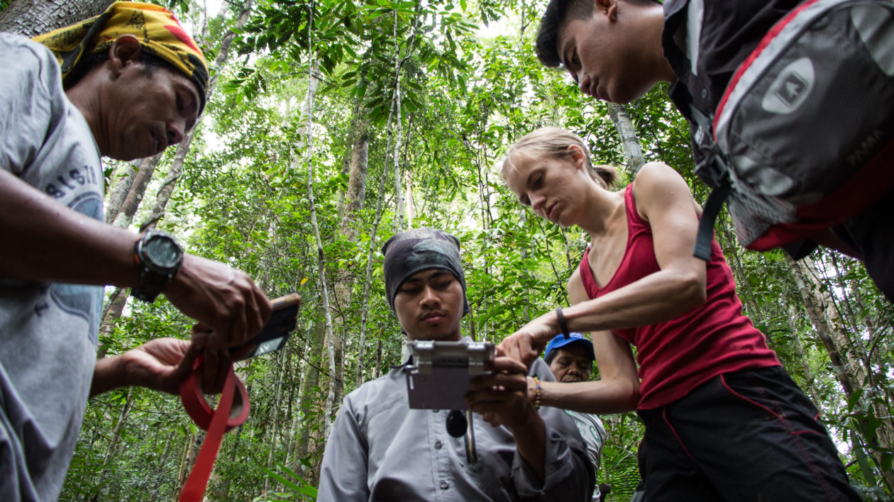 Four people in a circle working to deploy an acoustic reader.