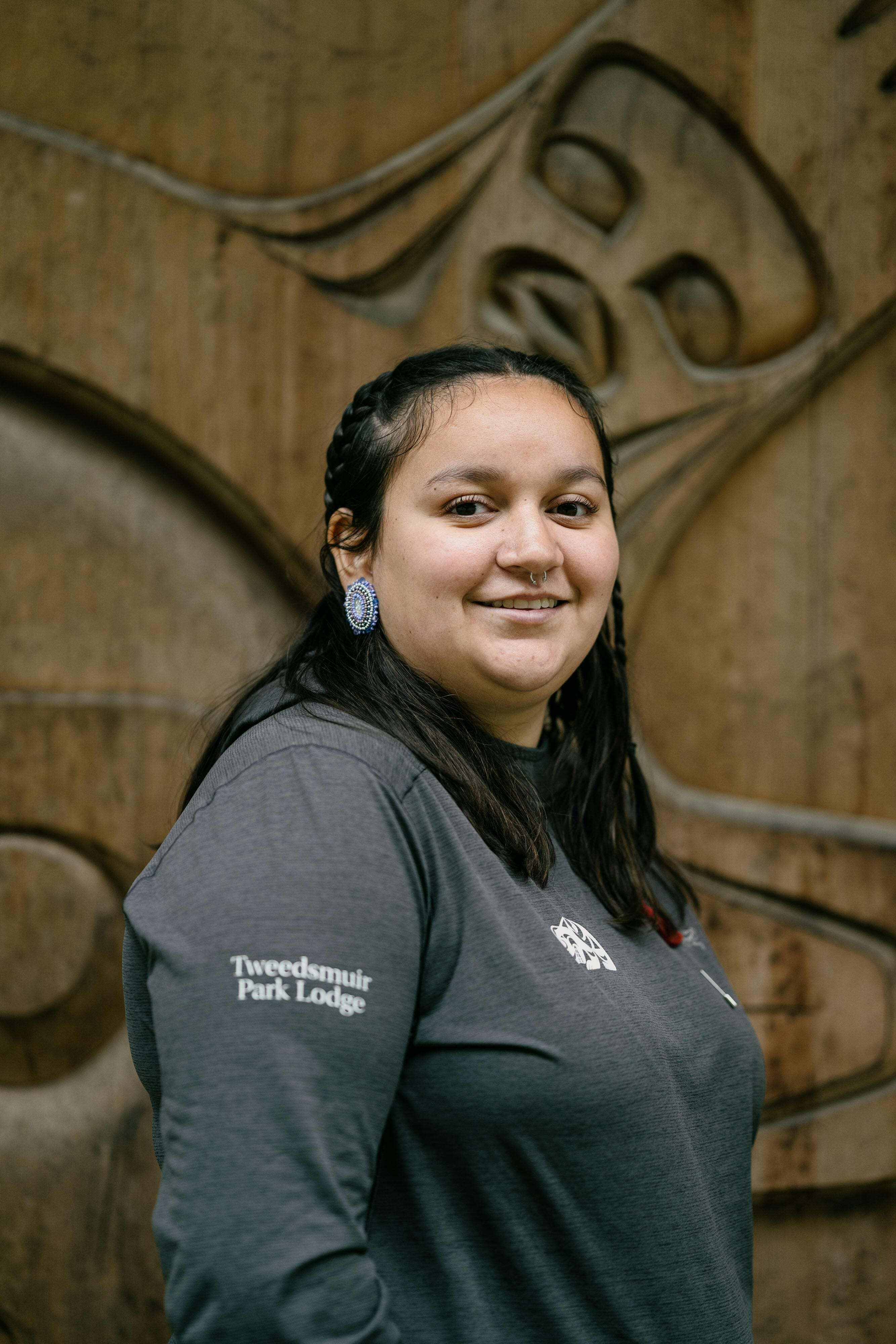Portrait of Shanti Tallio-Milton, a Nuxalk river guide, in front of Fisheries Pool Day Use Area shelter at Tweedsmuir Park on the Atnarko River, in Bella Coola, Canada.