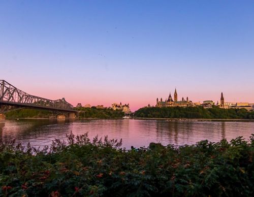 River in foreground with canadian parliament building in background.