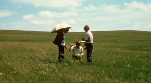 Historical photo of three people in a field collecting data.